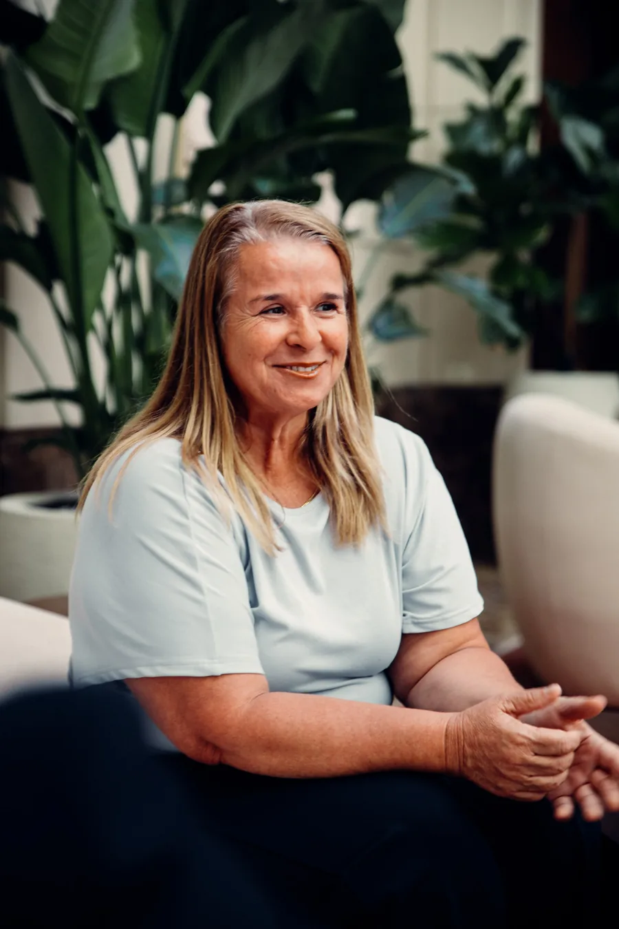 Yodi Richeson seated with her hands clasped, mid-conversation